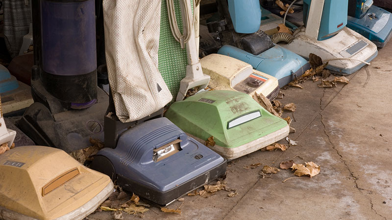 A line up of old and run down vacuums
